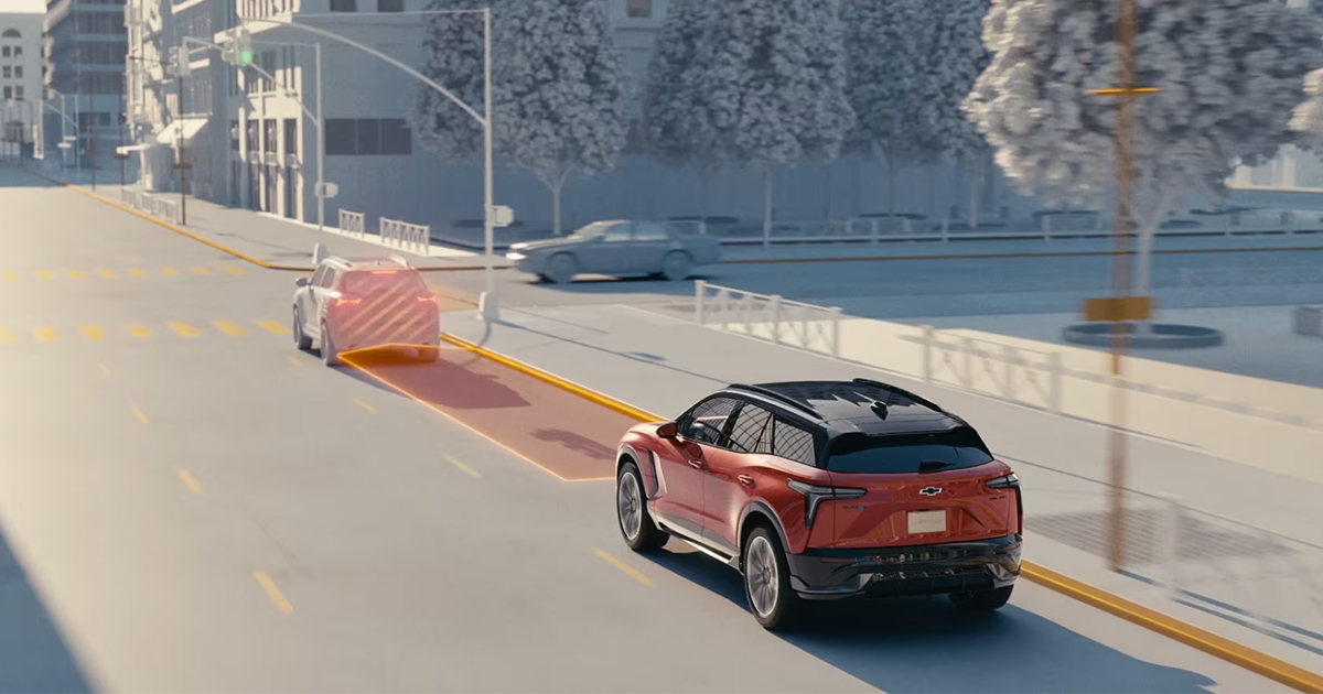 Red Chevrolet Blazer EV on city overpass demonstrating automatic emergency braking with visual detection overlay