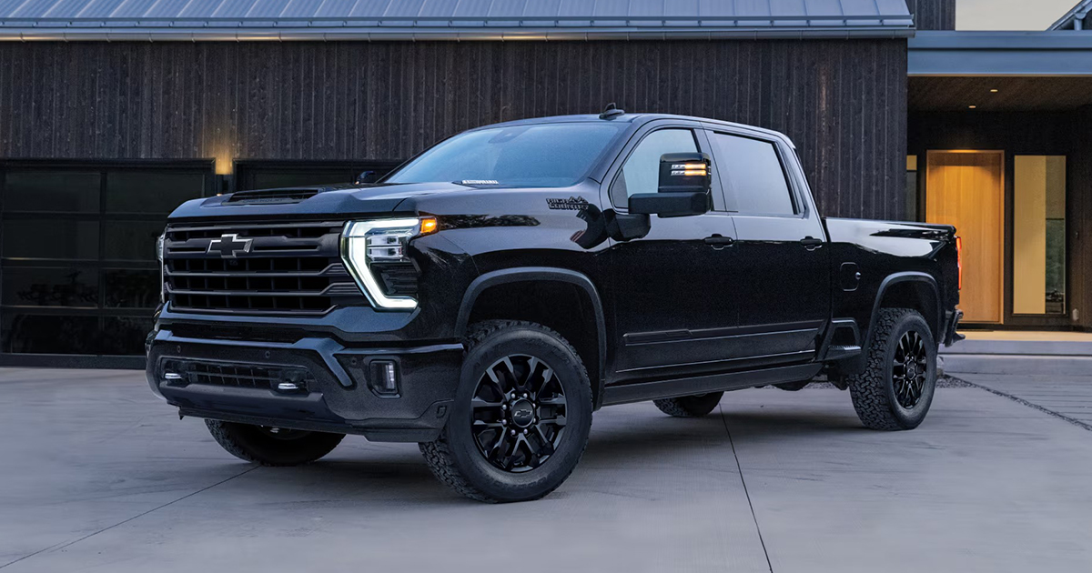 Black Chevrolet Silverado HD pickup truck parked in front of modern residential building