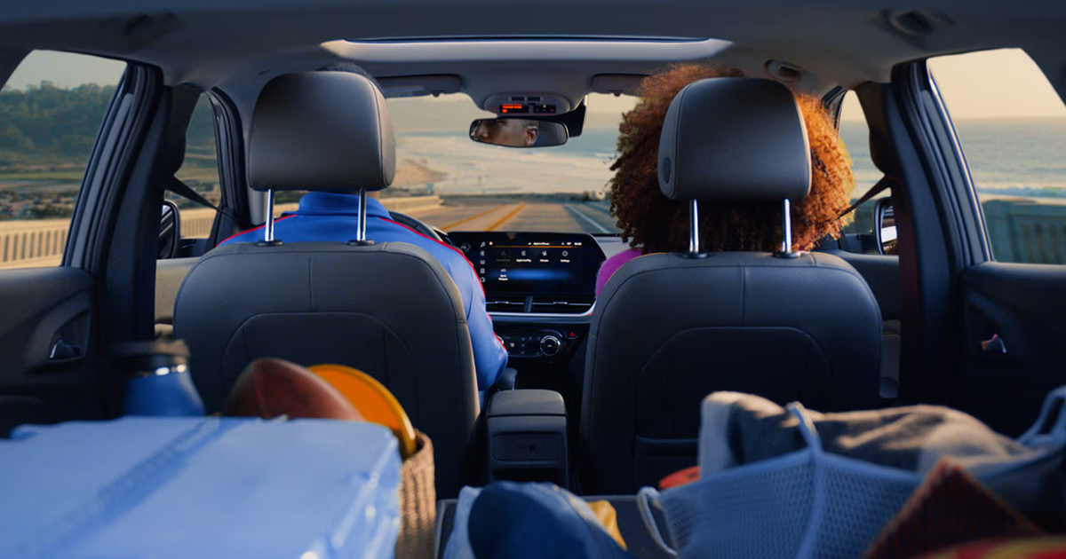 Interior view of Chevrolet Trax showing family with camping gear, digital dashboard display visible