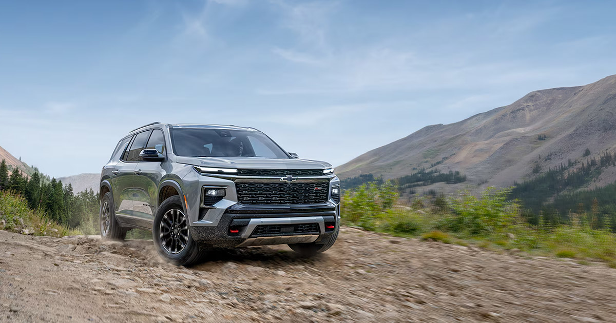 Silver 2025 Chevrolet Traverse Z71 driving on mountain dirt road with scenic backdrop