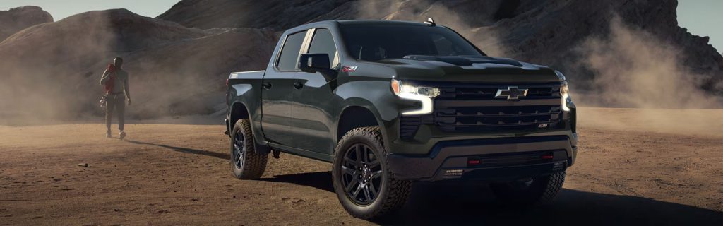 A Chevrolet Silverado Z71 sits in a dusty desert as a lone traveler walks nearby.