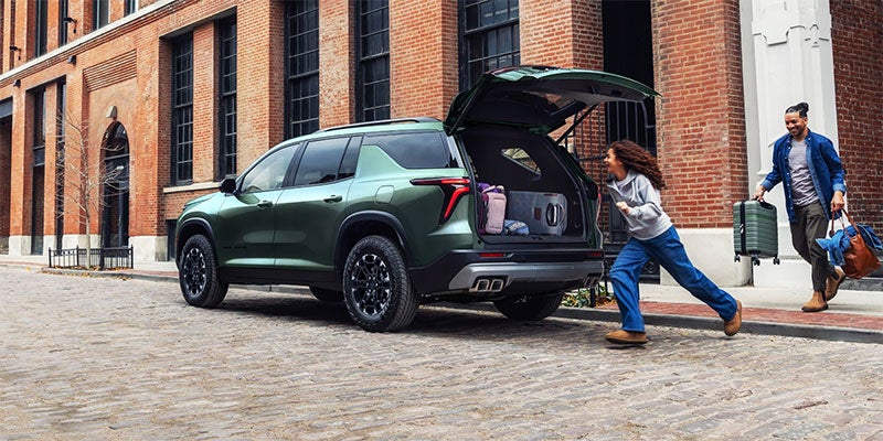 A family putting luggage into a Chevrolet Traverse
